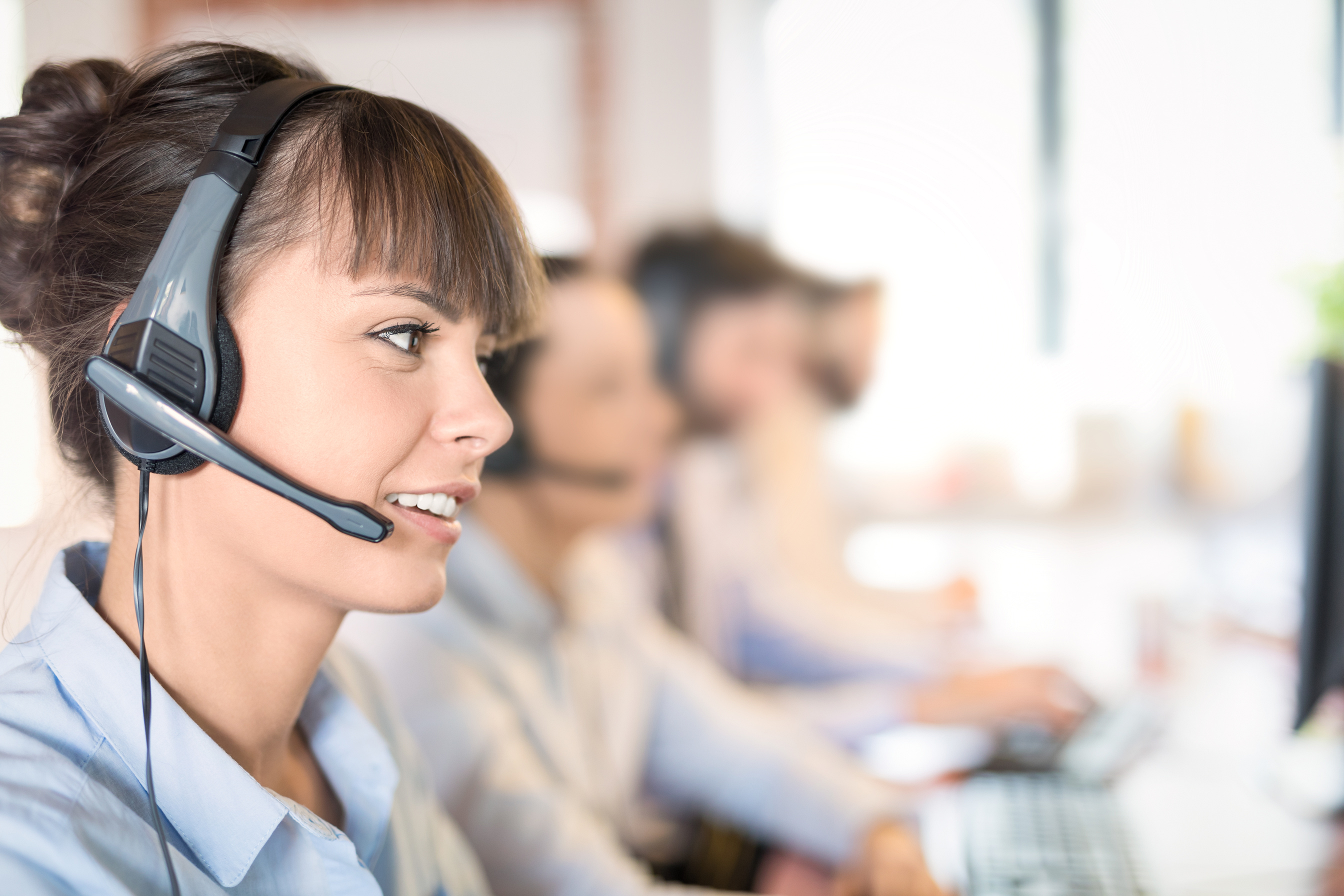 Call Center Agent with Headset Working on the Computer